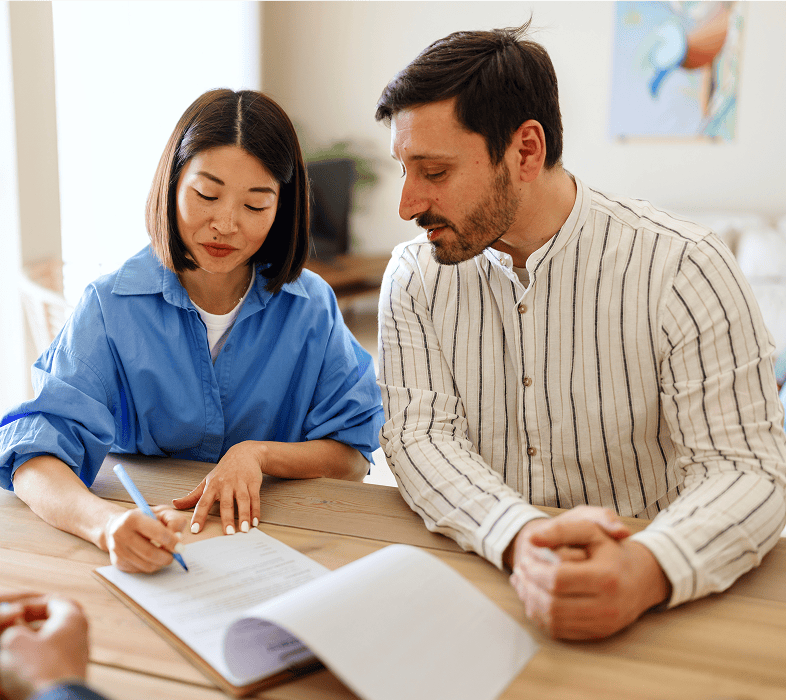Two people reviewing documents at a table.
