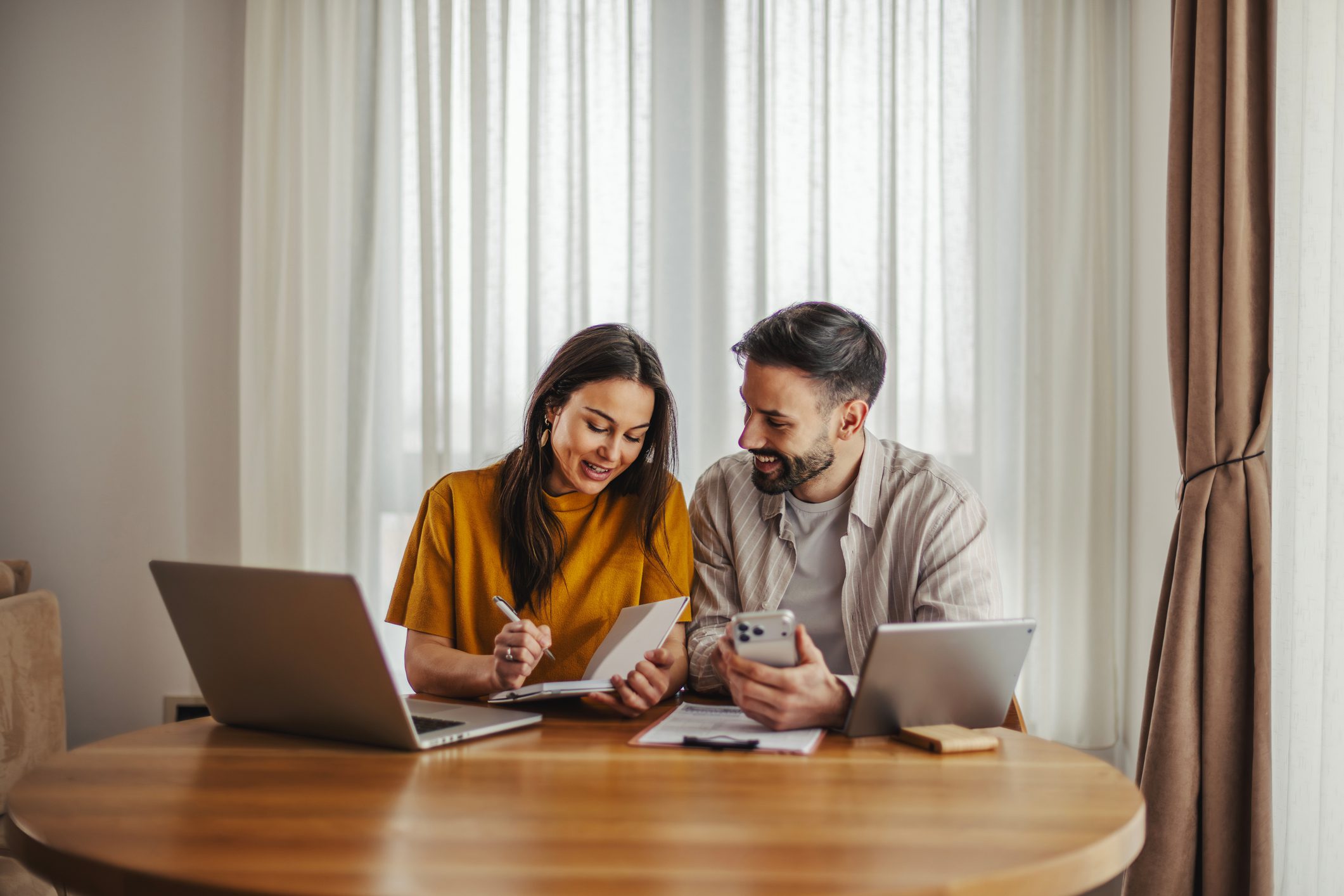 Smiling couple planning finances at home