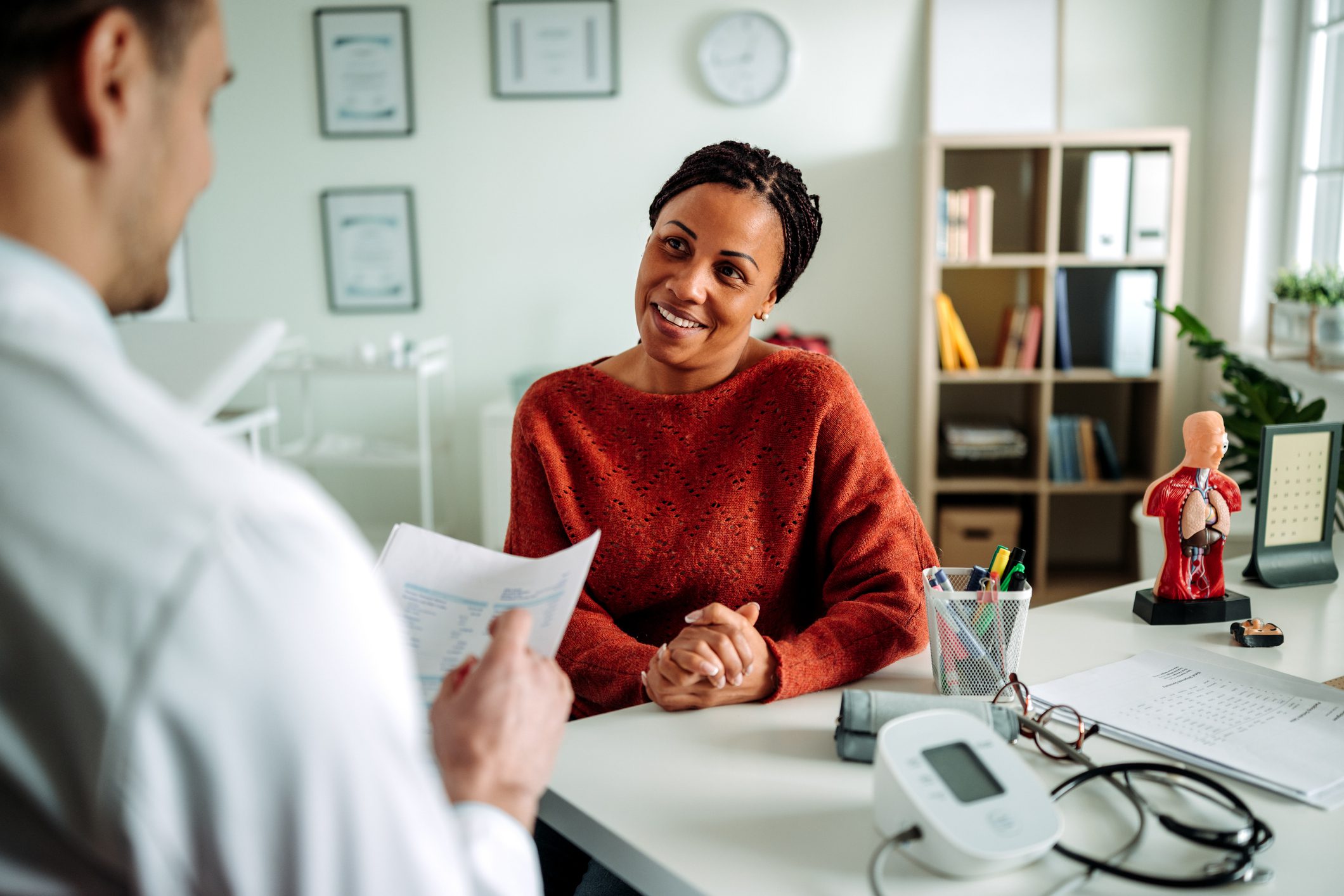 Smiling patient consulting doctor in clinic
